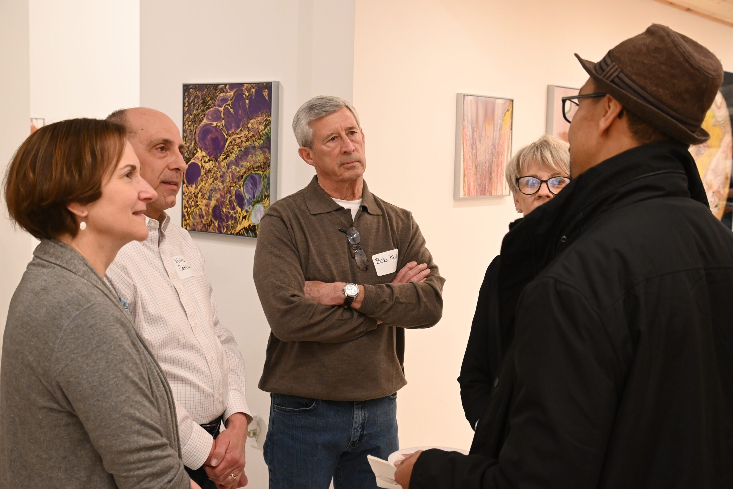 A group of adults stand in a circle talking and meeting.