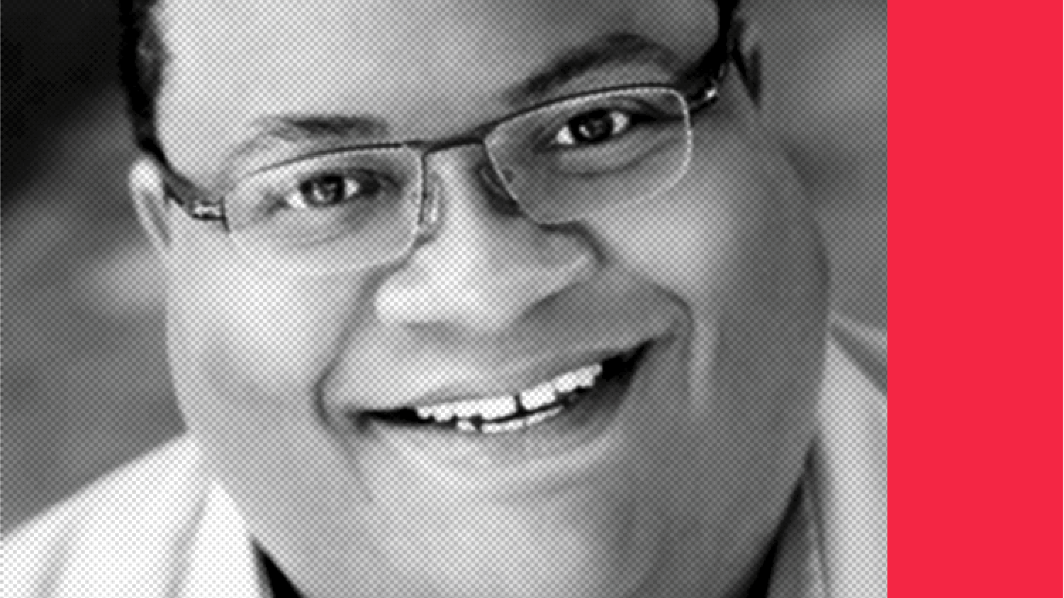 Headshot of a smiling person of medium skin tone, with short black hair, and wearing thin framed glasses and a white shirt.