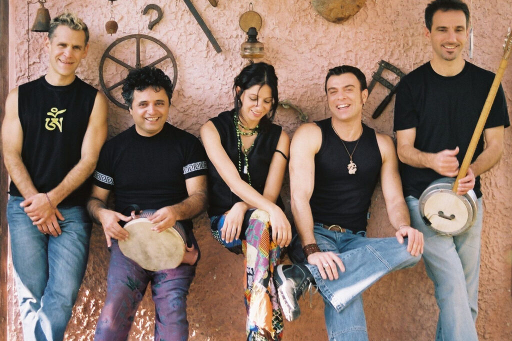 Esta, a multi-ethnic band from Israel, pose while leaning up against a wall adorned with various objects.