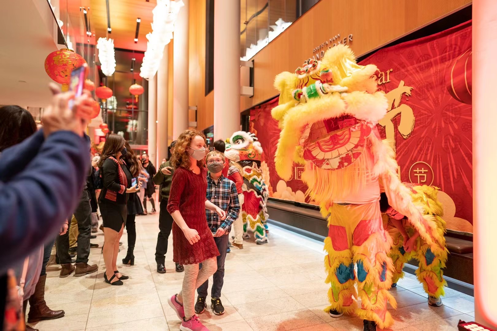 A lion puppet greets children at a Chinese New Year Celebration.