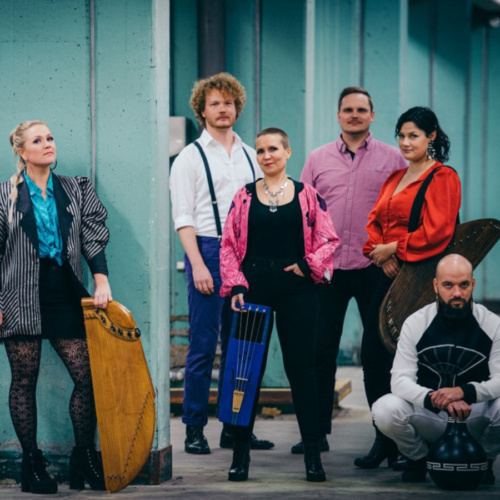 Finnish music group Okra Playground stand together for a photo, holding various instruments including a jouhikko.