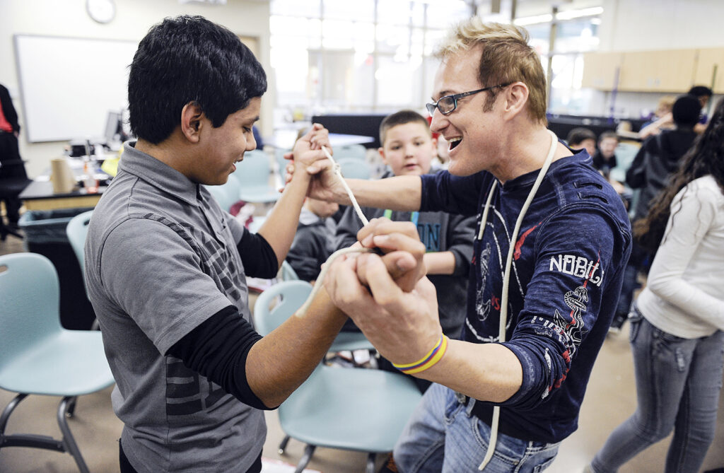 Illusionist Kevin Spencer smiles as Martin Perales gets a trick to work during a visit to I.J. Holton Intermediate School Tuesday.
