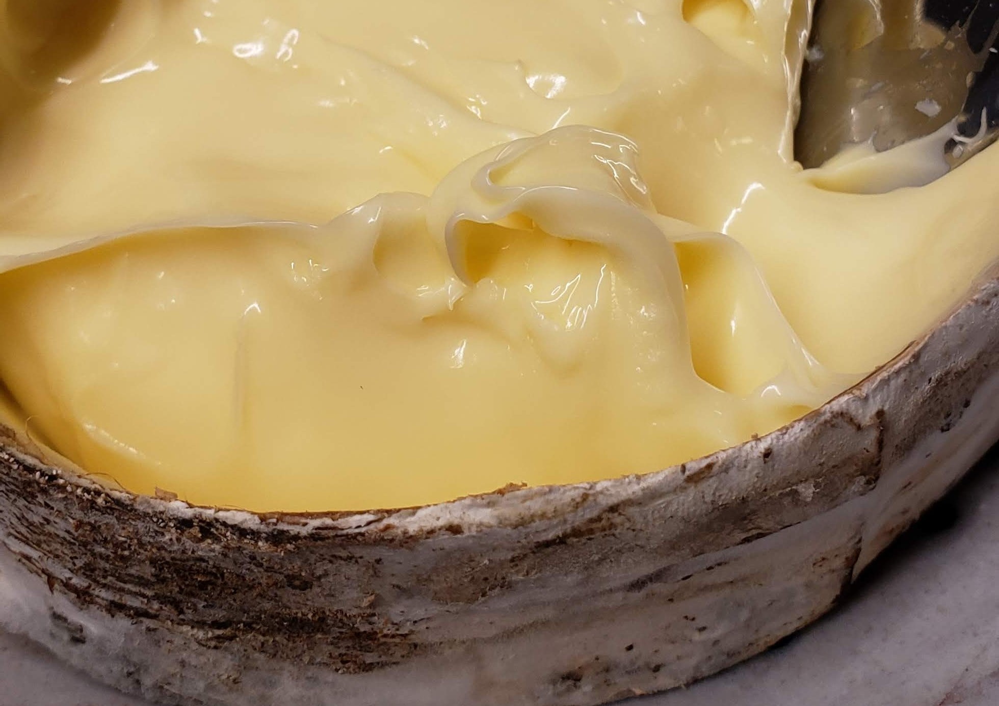 A close-up of the Rush Creek cheese with a custardy texture and light-yellow color.