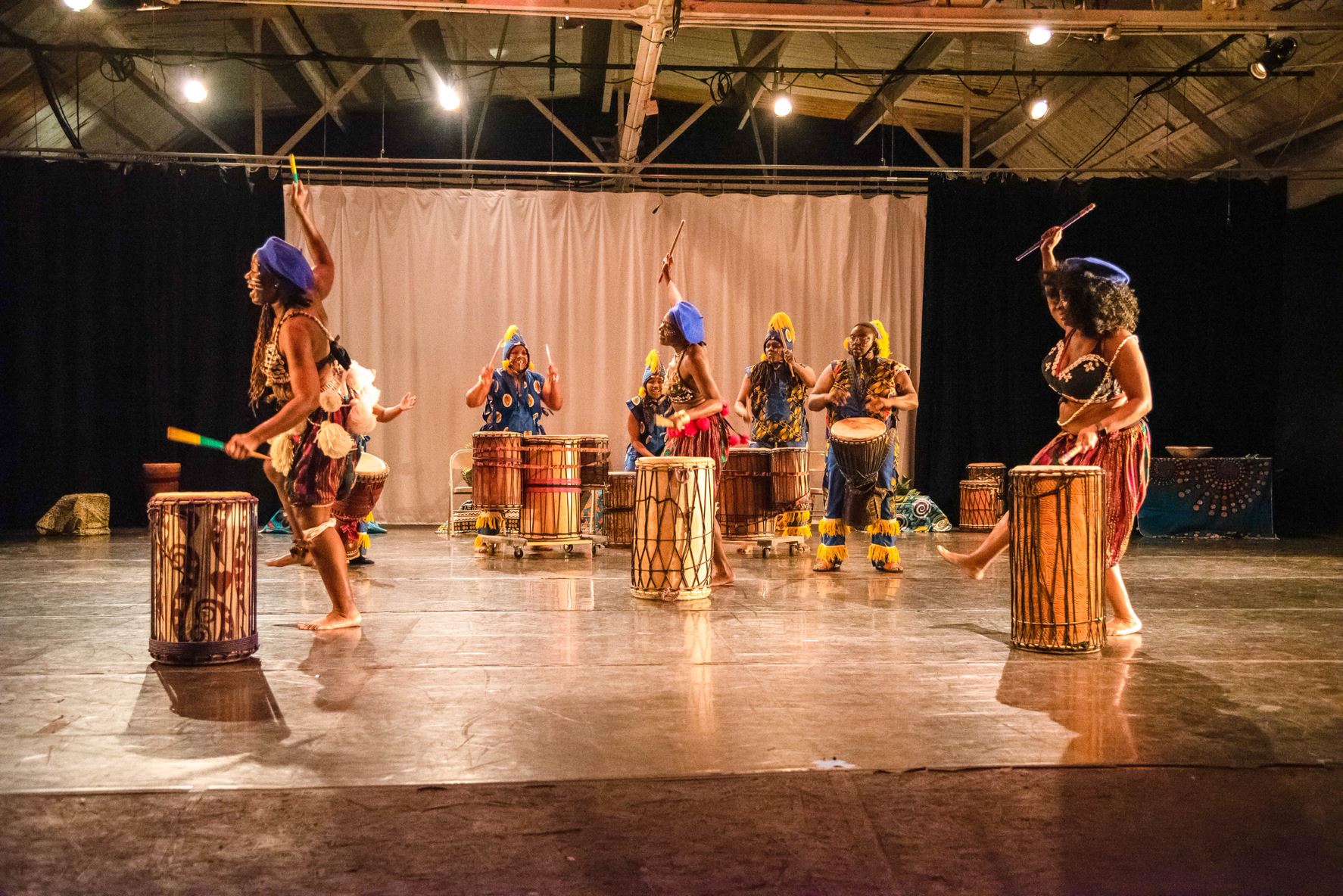 A group of women participating in a traditional West African drum and dance performance.