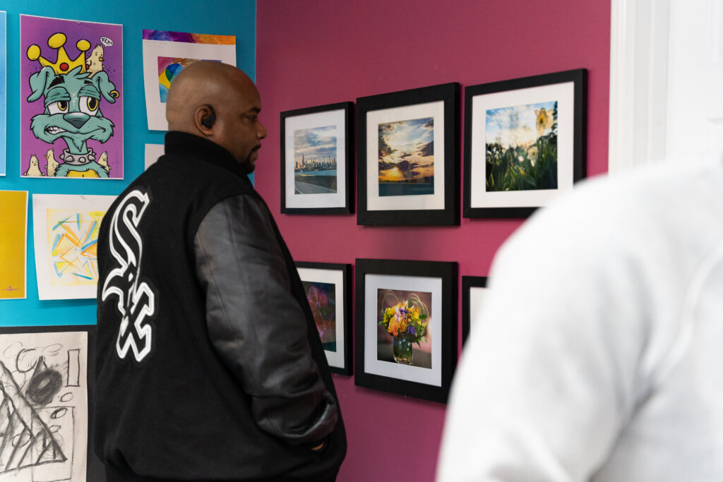 A man looks at a series of beautiful nature photographs hung on a wall