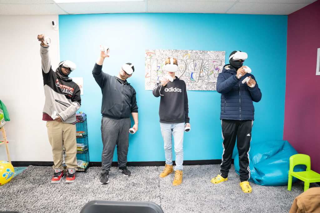Four students wearing VR headsets pose for the camera.