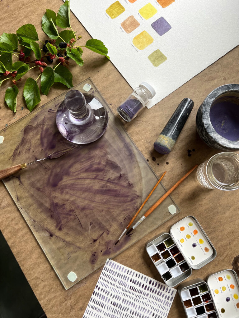 An assortment of tools used in extracting color pigment from plants laid out on a table.
