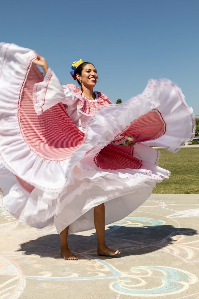 A mexican dancer performing with a large pink and white skirts at an NEA Big Read event.