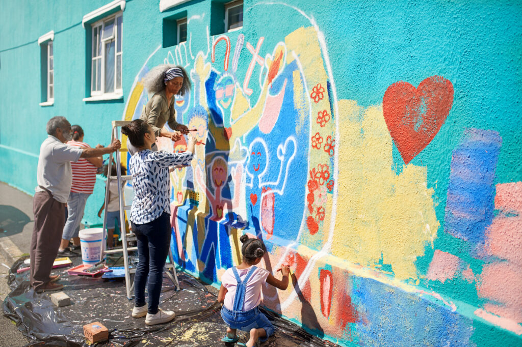 A group of people paint a colorful mural