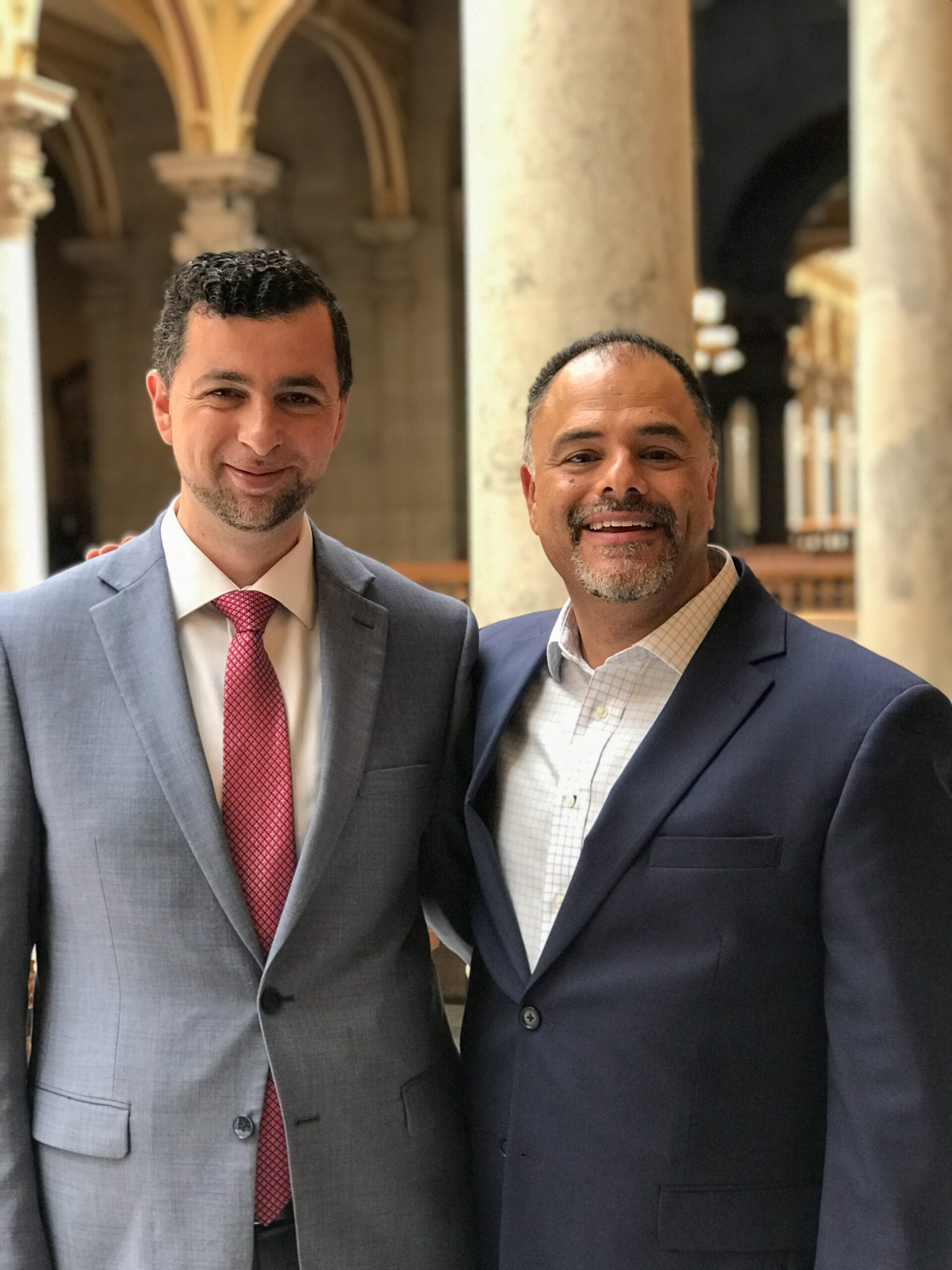 Two Arab men in suits pose for a picture together