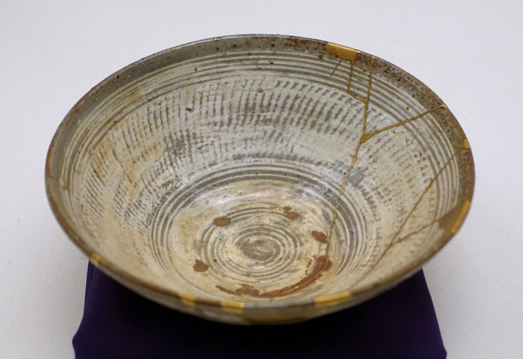 A cracked bowl that has been pieced together with gold