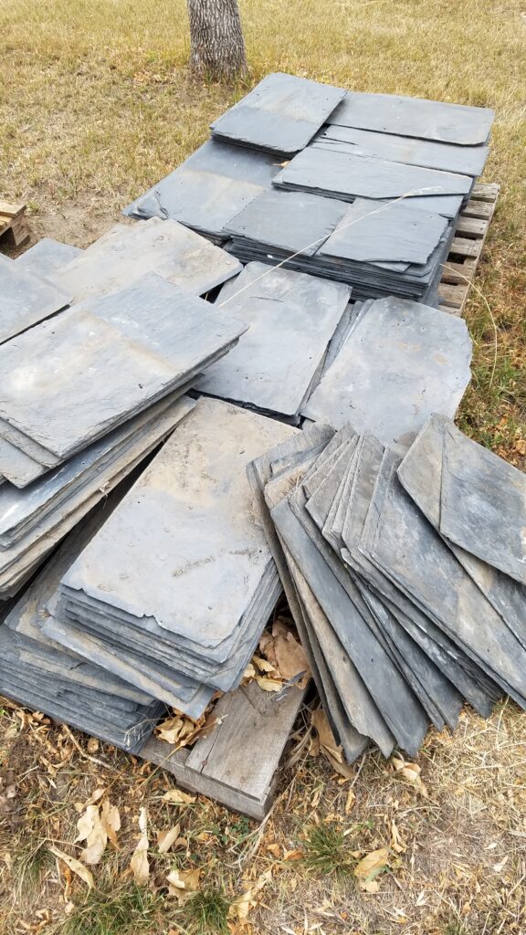 A pile of slate roof tiles on the ground