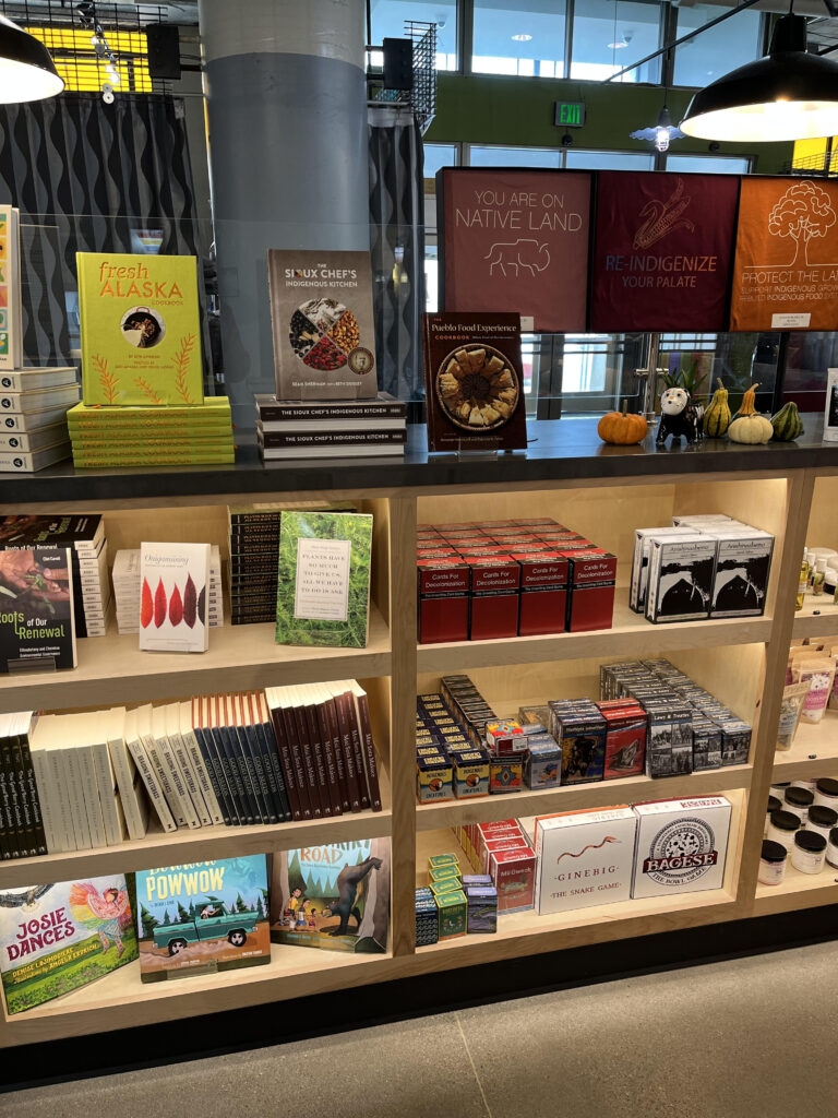 Cookbooks and other indigenous inspired merchandise are displayed on shelves.