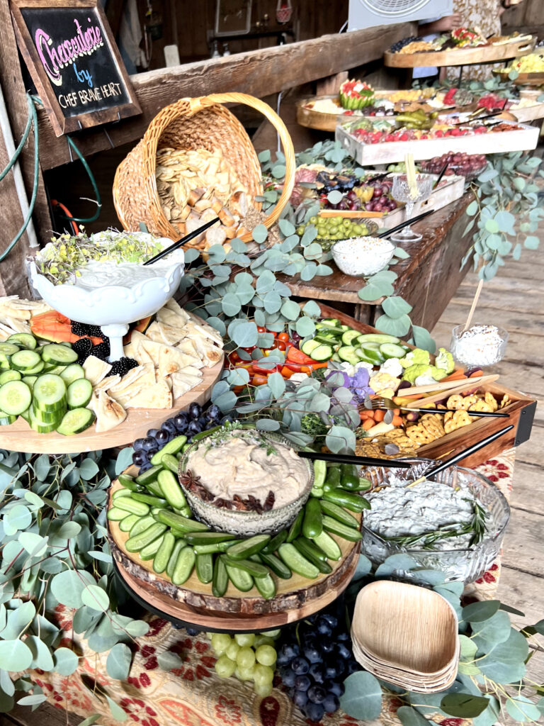 A wide assortment of vegetables and dipping sauces, displayed in a rustic setting.