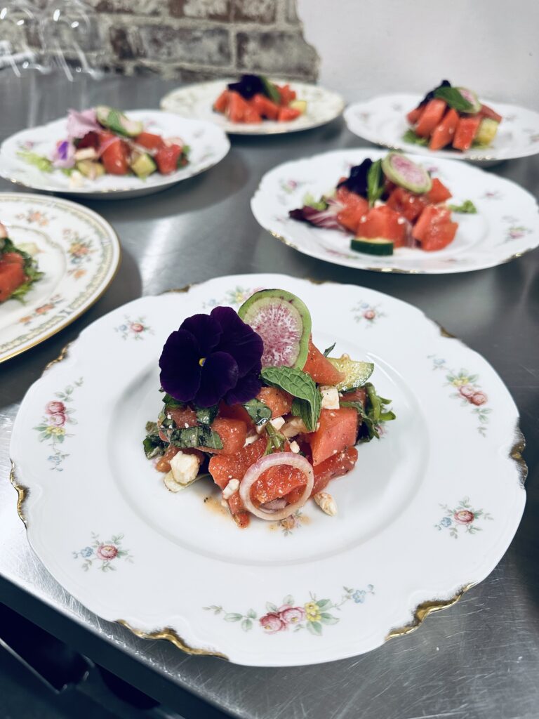 Six plates of salad with a flower garnish.
