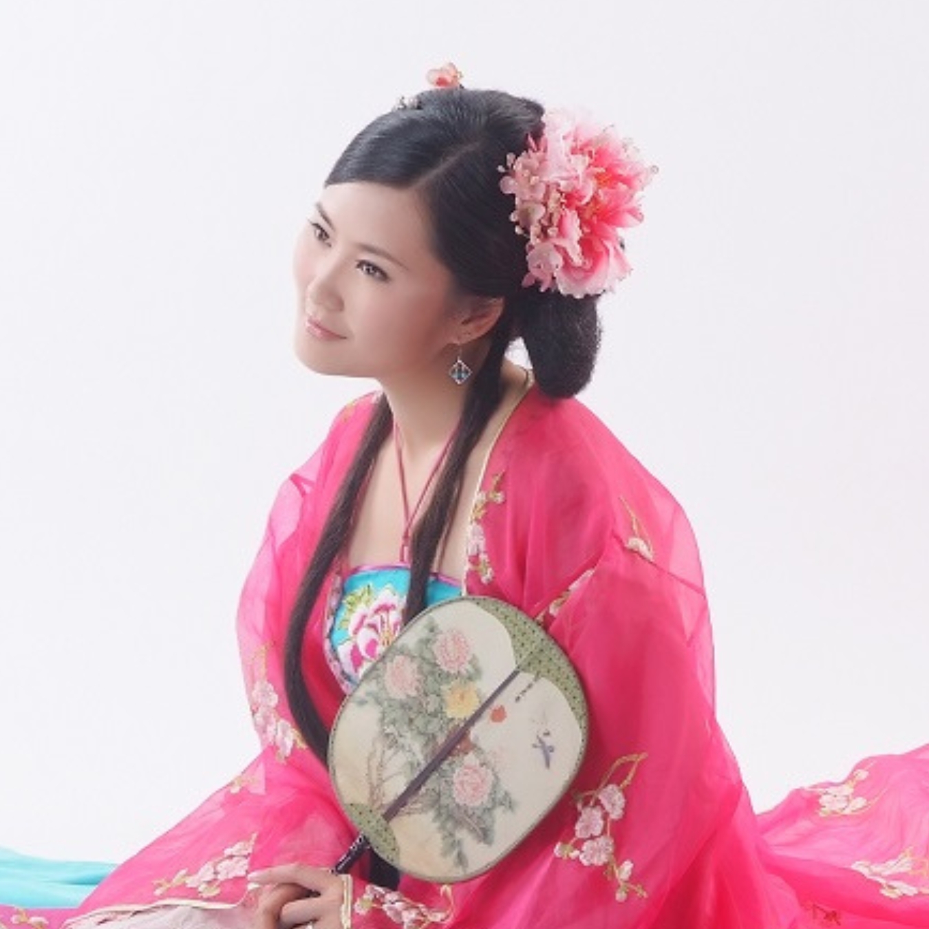 Headshot of a person with light skin tone with long black hair wearing traditional Chinese garments.