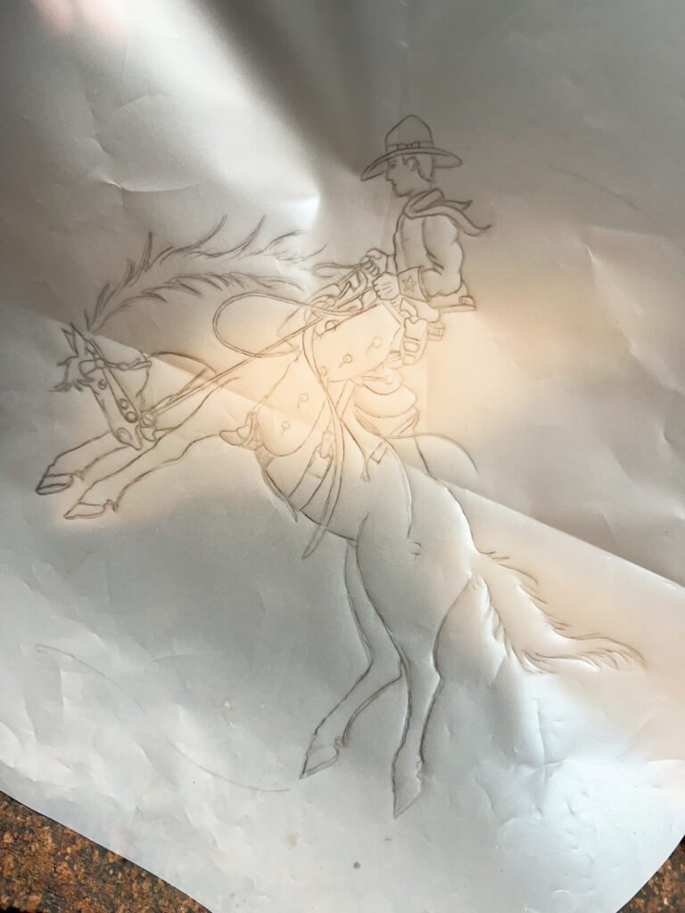 A pencil line drawing of a cowboy rancher mid-air on their horse, done on white paper.