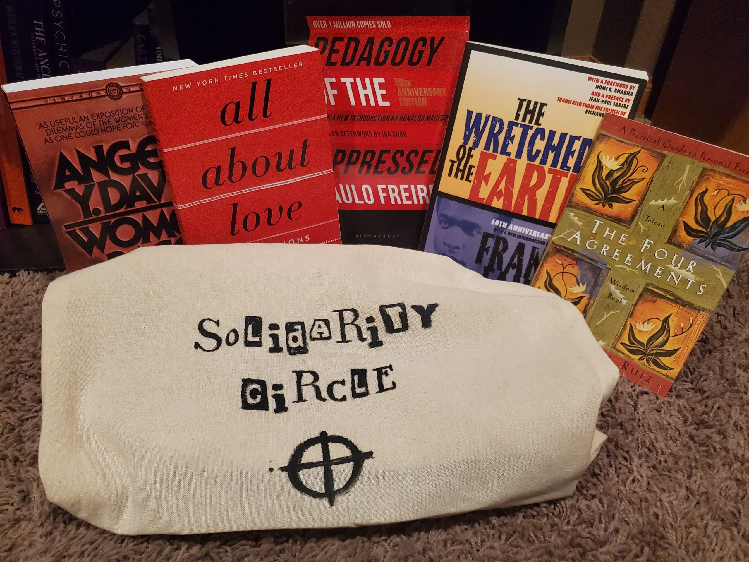 Five books and a tote bag reading, "Solidarity Circle."