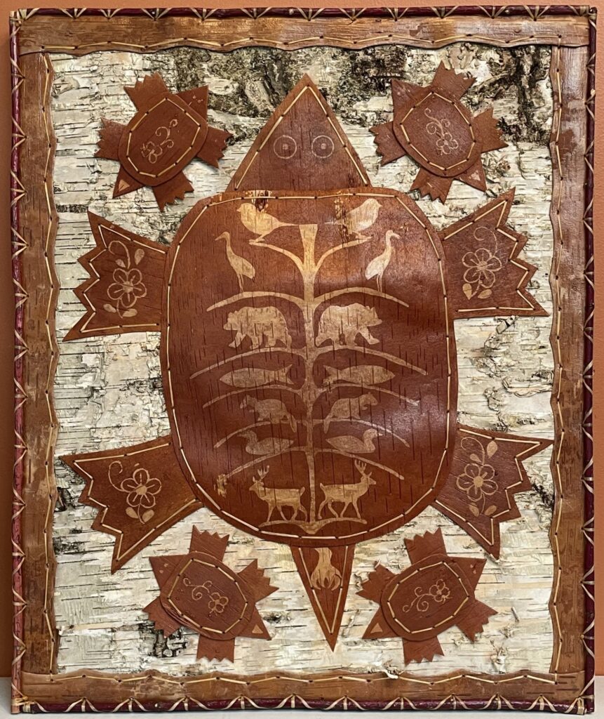 A birchbark artwork of a large turtle with surrounded by four smaller turtles.