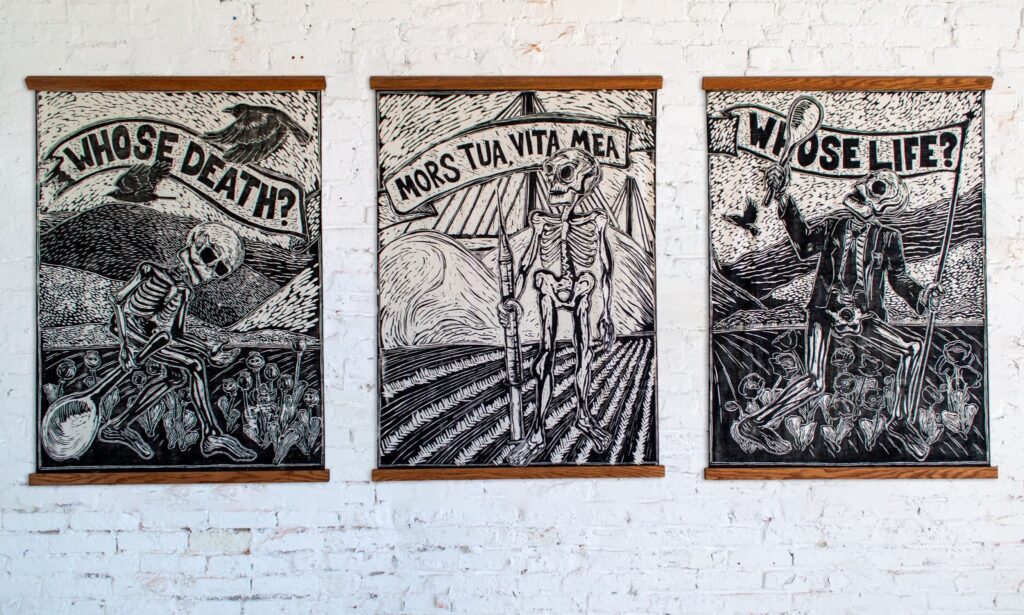 Three black and white prints depicting a skeleton in various position. In one it carries a large object like a giant spoon through a field and the text above reads "Whose Death?" In another, it stands with a spear in the middle of a field with short crops and the text above reads "mors tua, vita mea." In the third, it is clothed in a suit and tie and raises the spoon above its head in a patch of flowers. The text is "Whose life?"