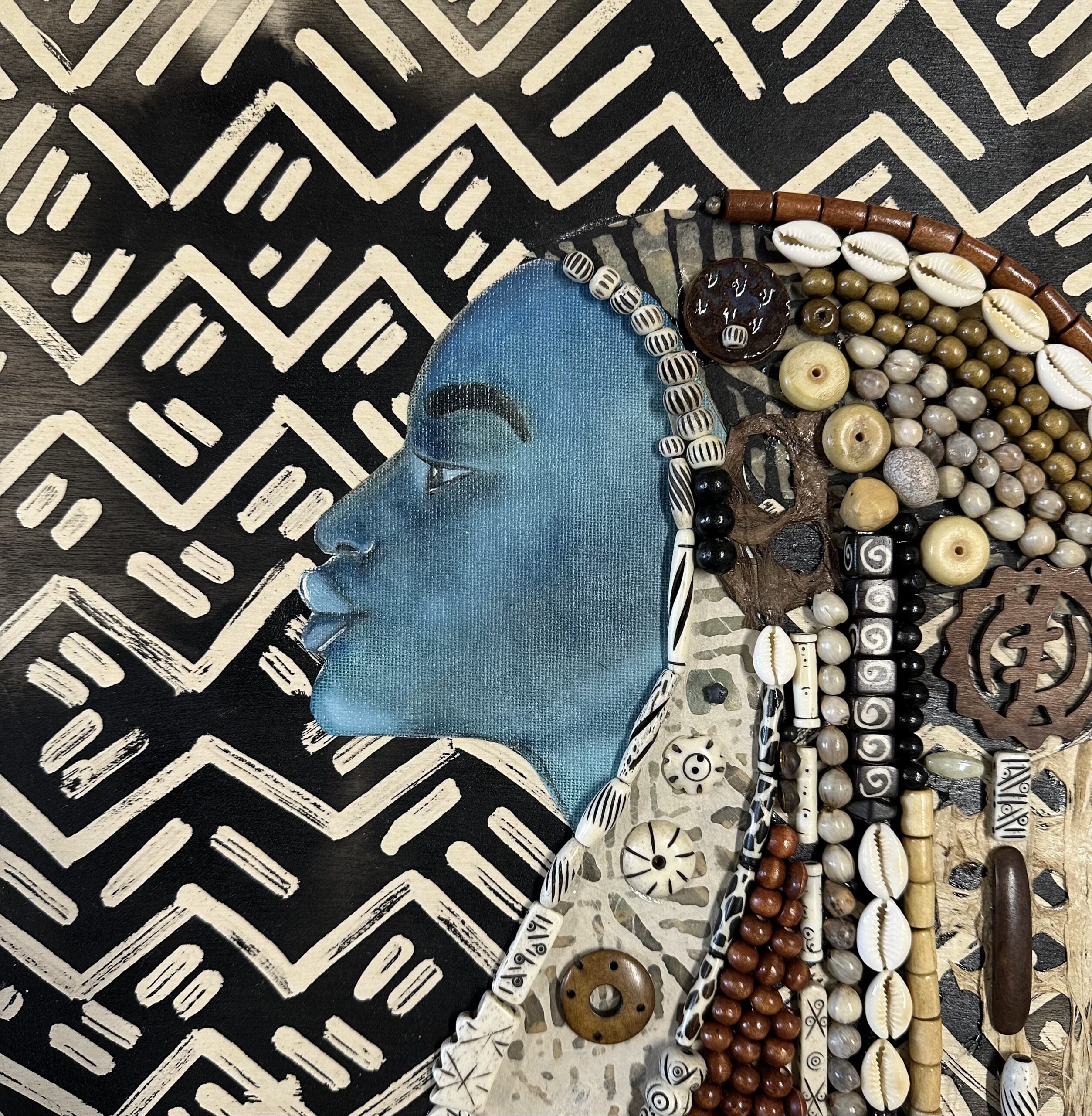 A mixed media artwork of a woman with blue skin with hair made up of various shells, seeds, and other found objects.