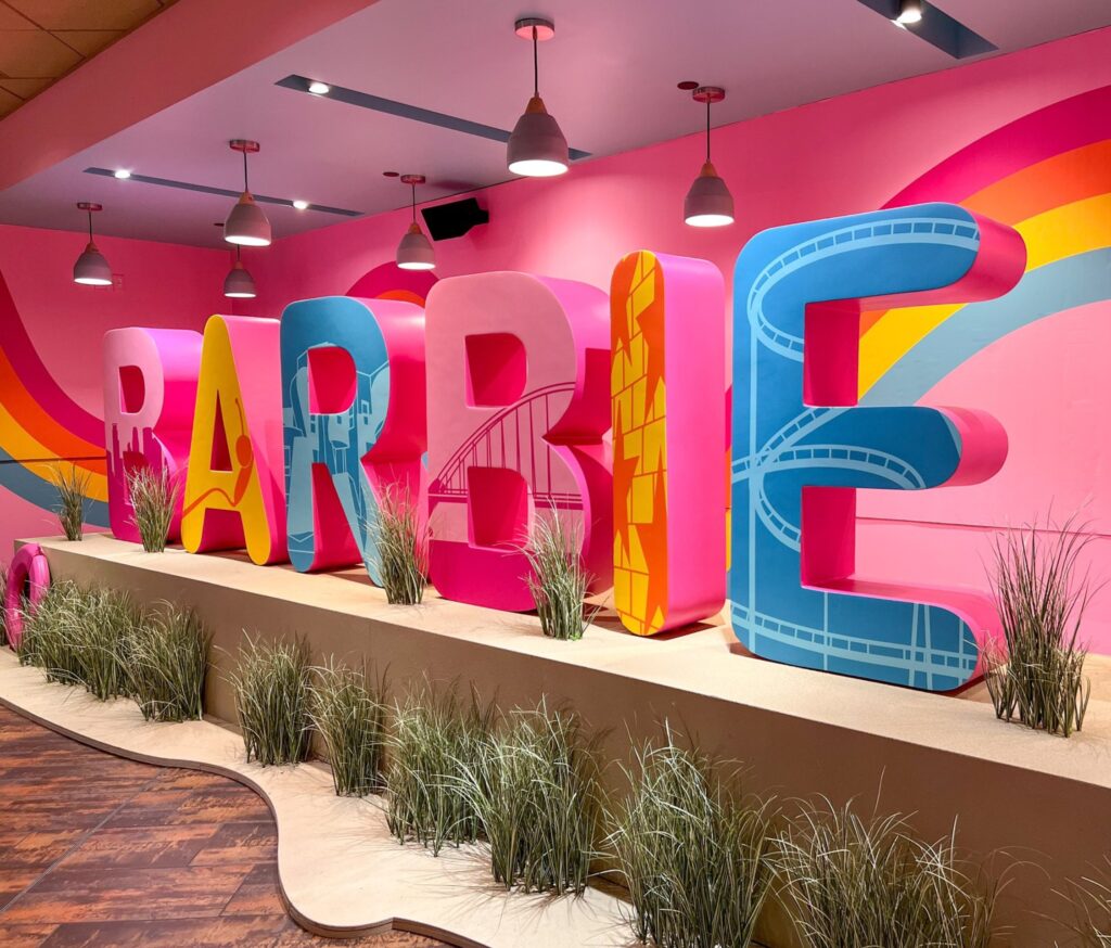 A colorful sign made up of six large letters spelling "Barbie," with different Twin Cities landmarks on each letter.