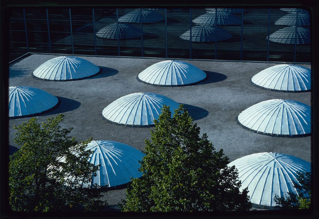 A roof of a building with large shell-like architectural domes.