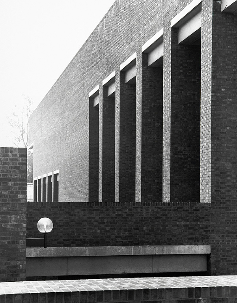 An exterior of a brick building with modernist architectural features.