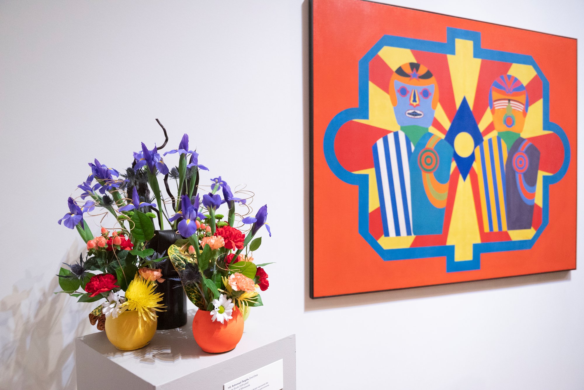 A colorful pop art painting and a floral arrangement interpreting it