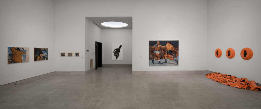 An art gallery with white walls with mounted artworks of varying sizes, colors, and textures.