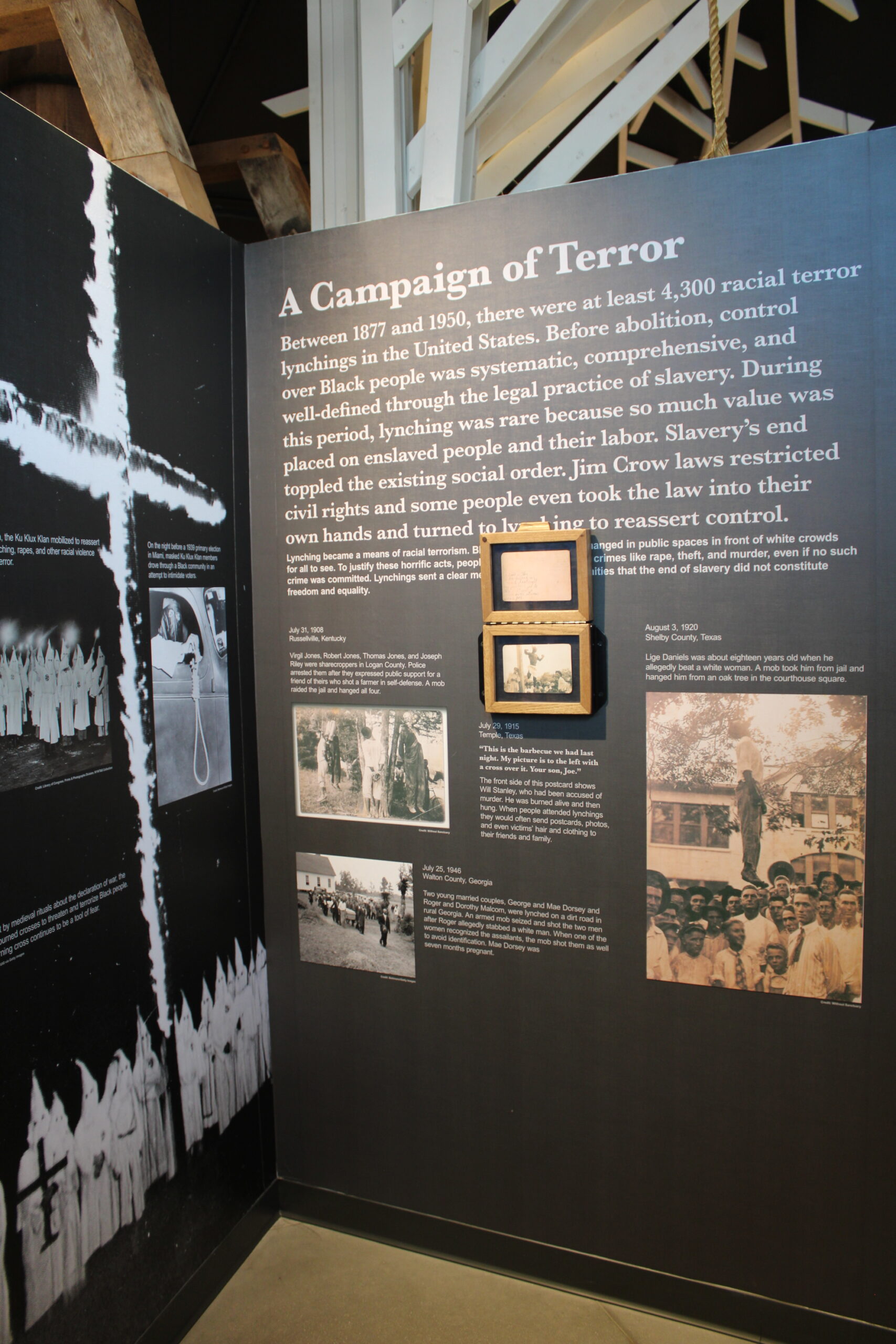 A museum display wall with text and photos. The title on the display wall reads "a campaign of terror" and has black and white archival photos.