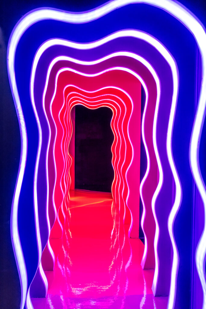A brightly lit hallway framed by squiggly light installations