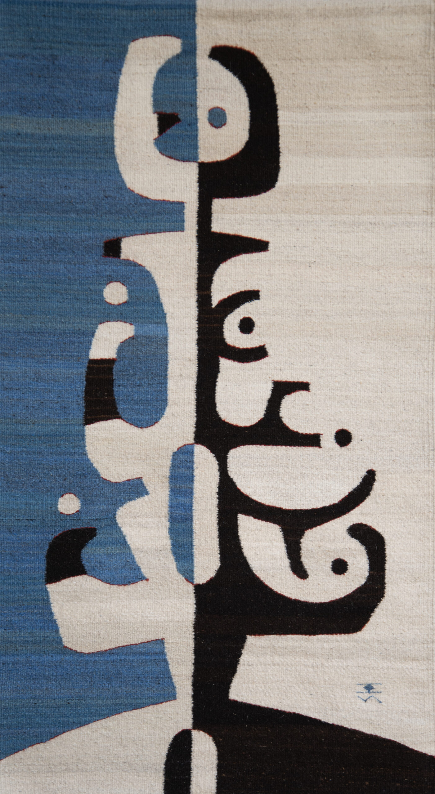 A woven textile work with abstract and geometric designs.