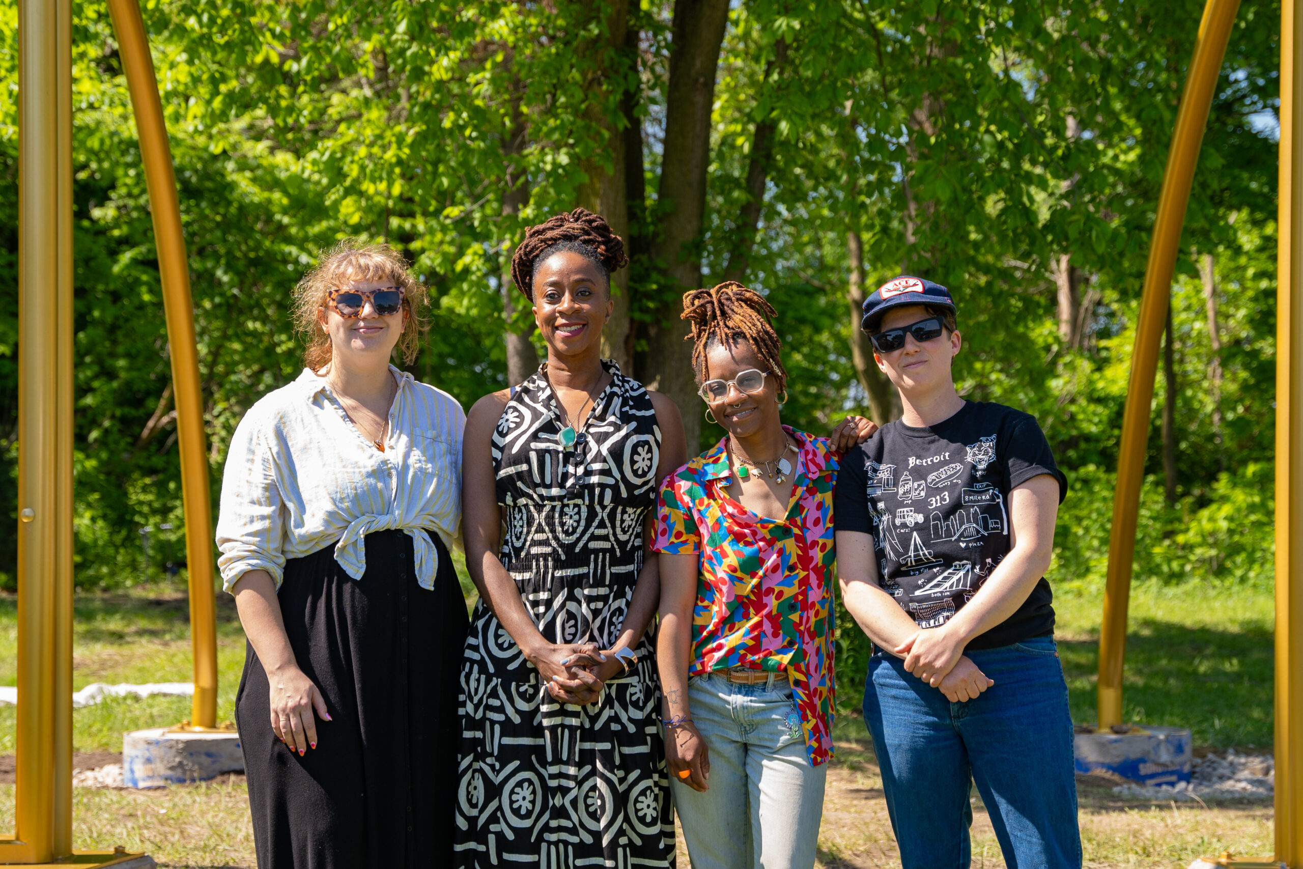 Four people stand together at a park.