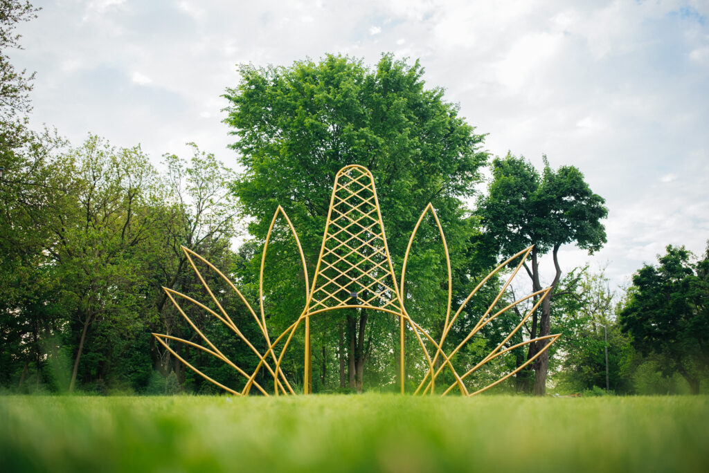 A sculptural artwork at a park that looks like a large gold crown.