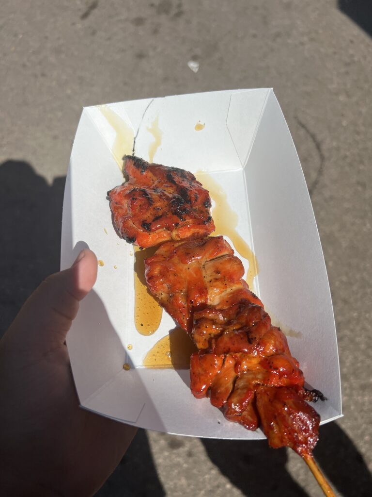 Several chunks of grilled chicken on a stick, with a brown teriyaki glaze.