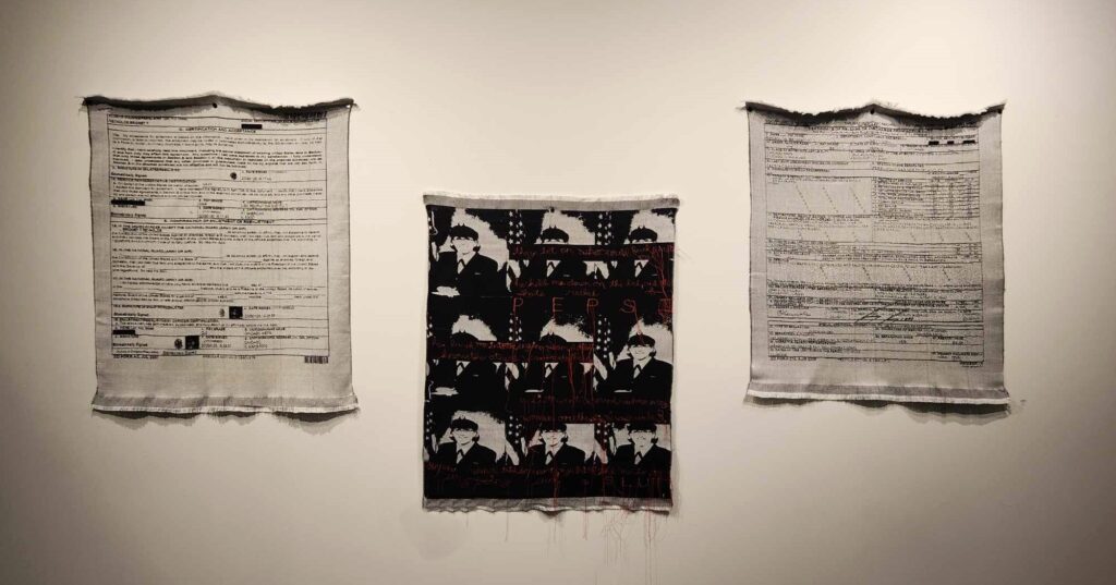 Three woven tapestries of Charlie Reynolds' military contract, bootcamp portrait, and discharge paperwork.