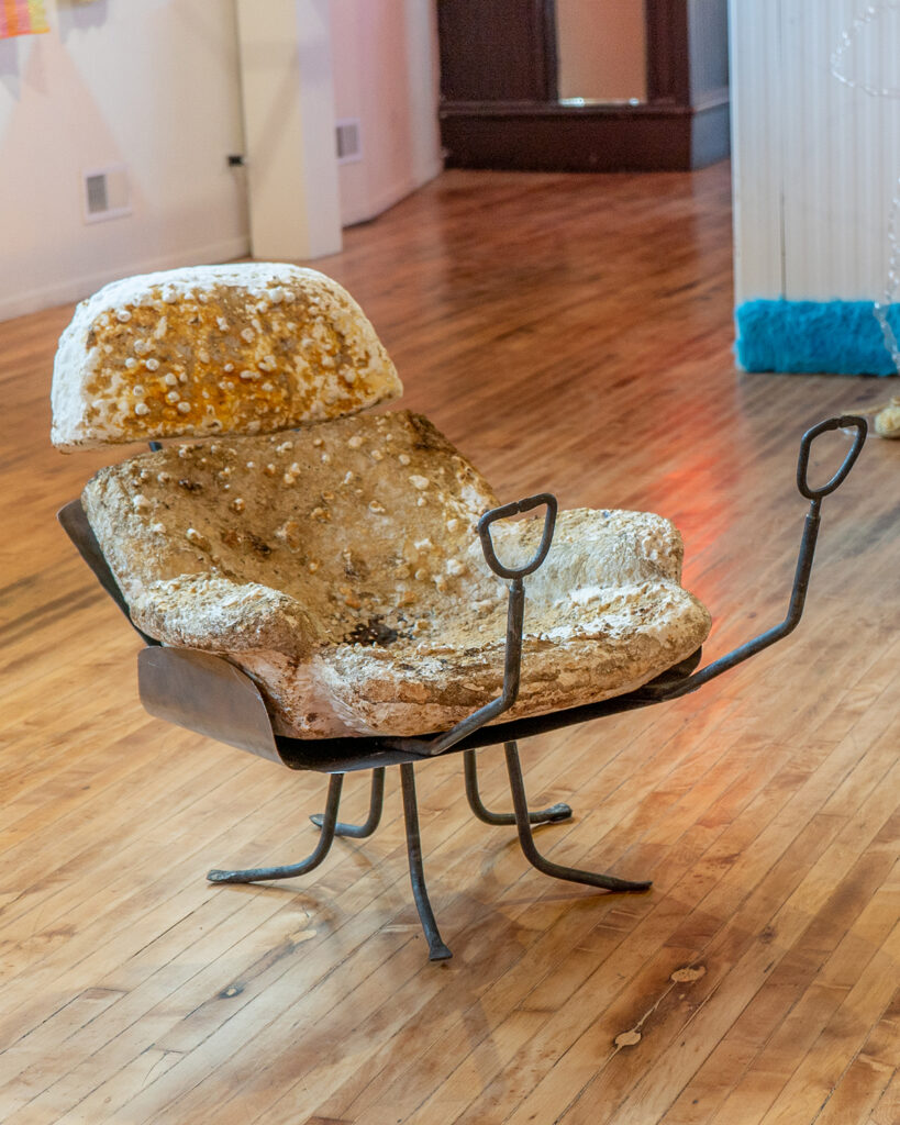 An OBGYN chair made of mushroom, with a steel base and stirrups.