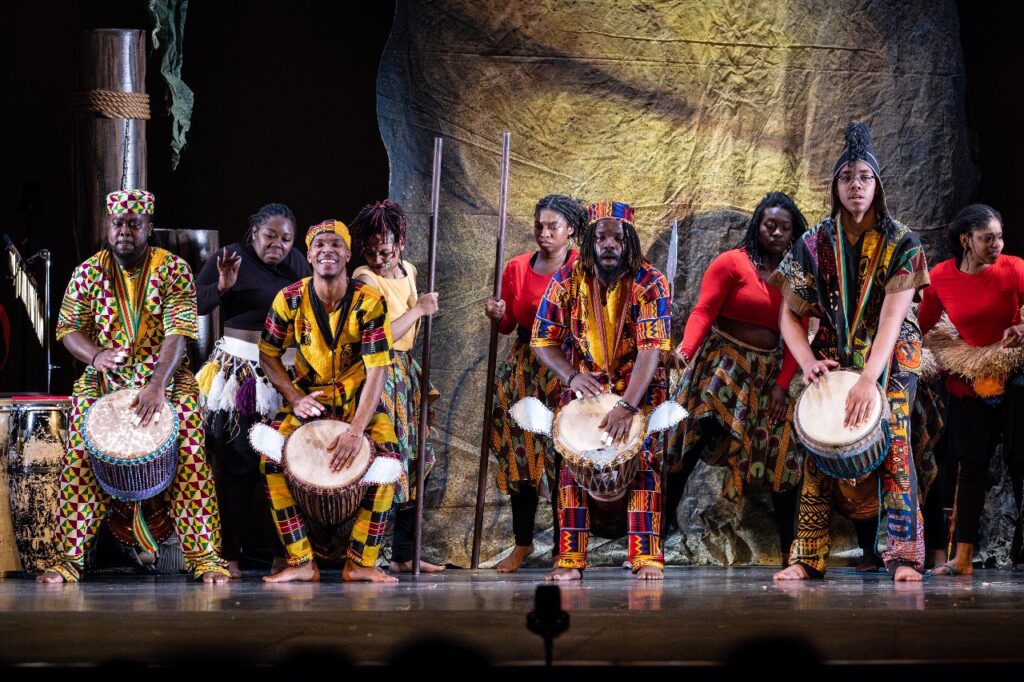 A group of dancers and drummers in traditional clothing from around the continent of Africa