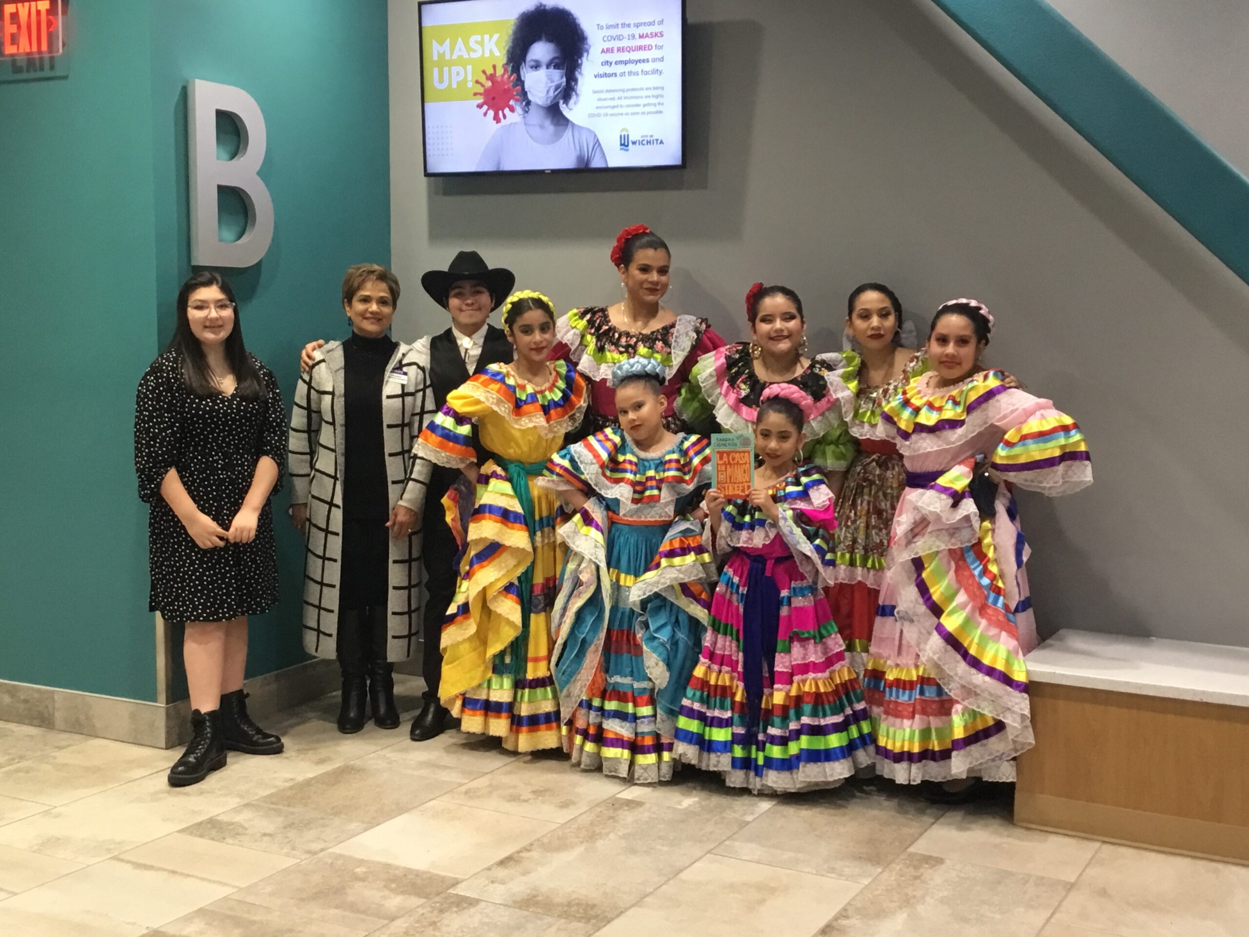 A group of 10 dancers in colorful mexican folklorico costumes