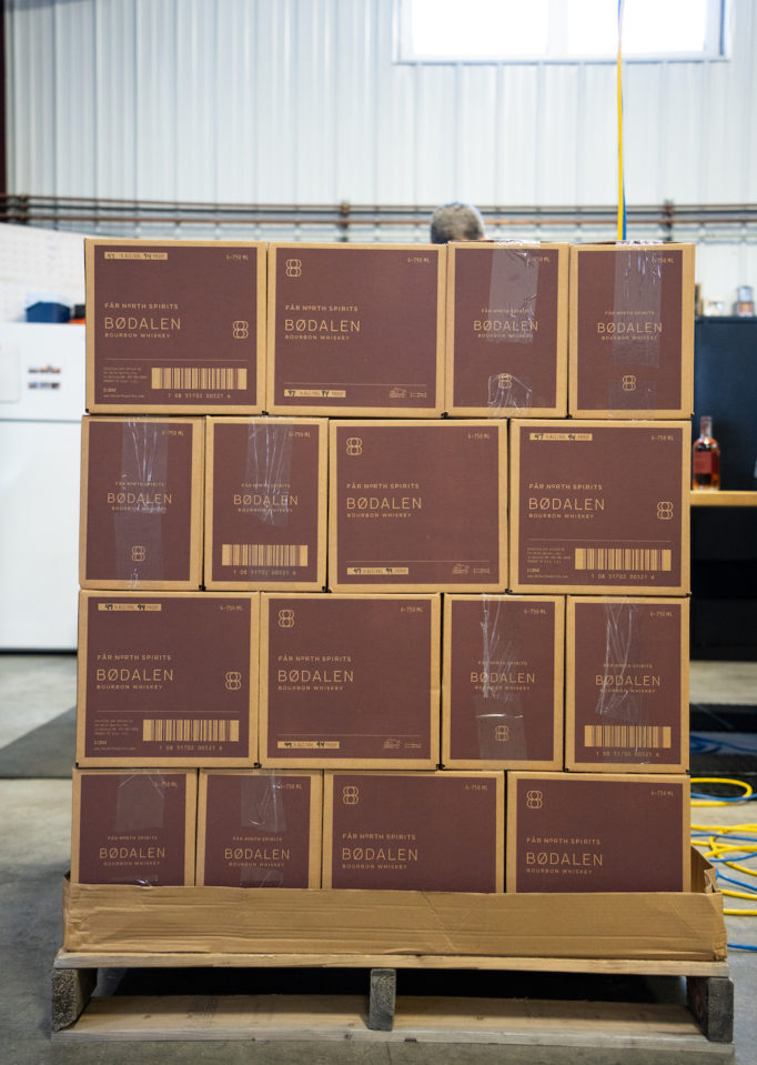 A stack of brown cardboard boxes on a wooden pallet.