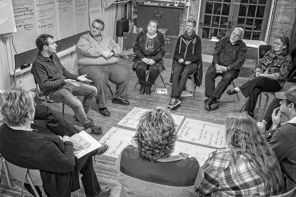 A group of people sitting in chairs arranged in a circle.