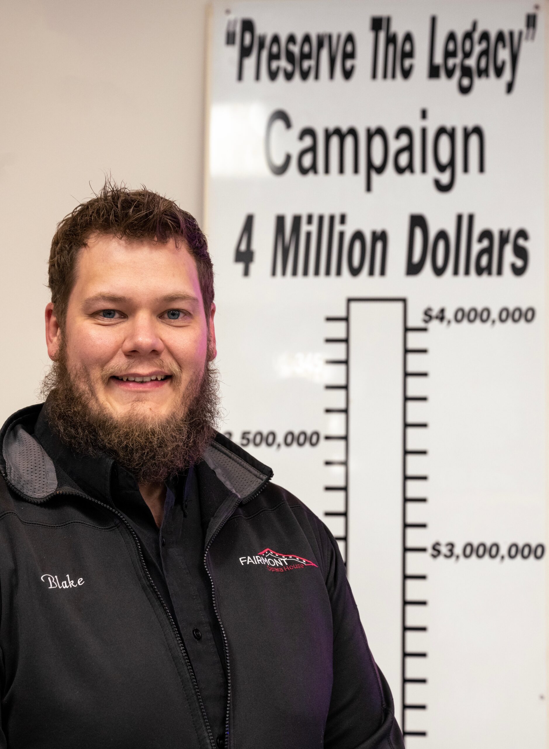 A white man next to a large bar chard that reads Preserve the Legacy Campaign 4 Million Dollars