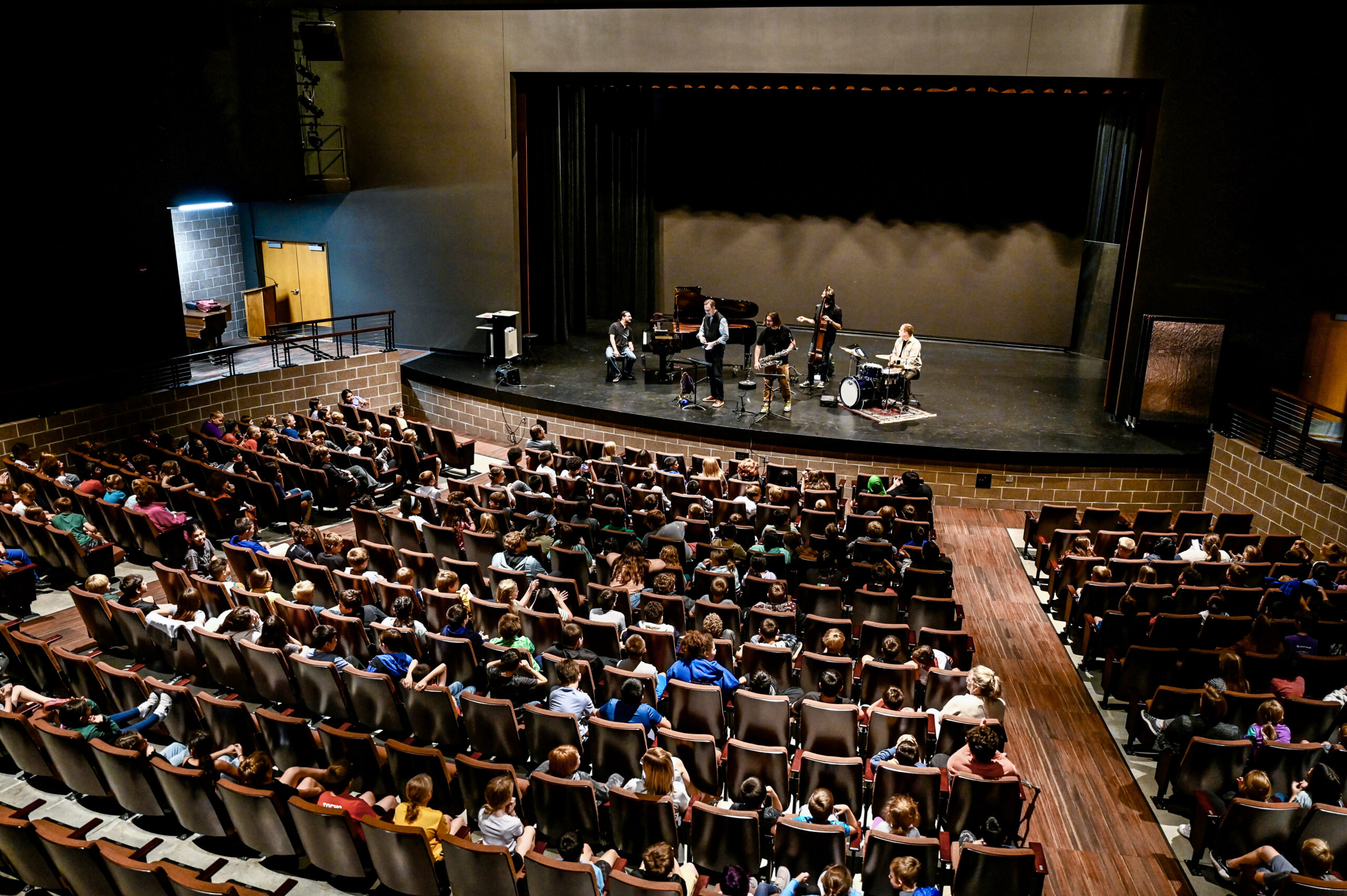 A group of musicians on stage at a student auditorium