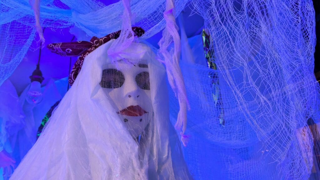 A ghost decoration with red lips and black eye sockets surrounded by white gauze.