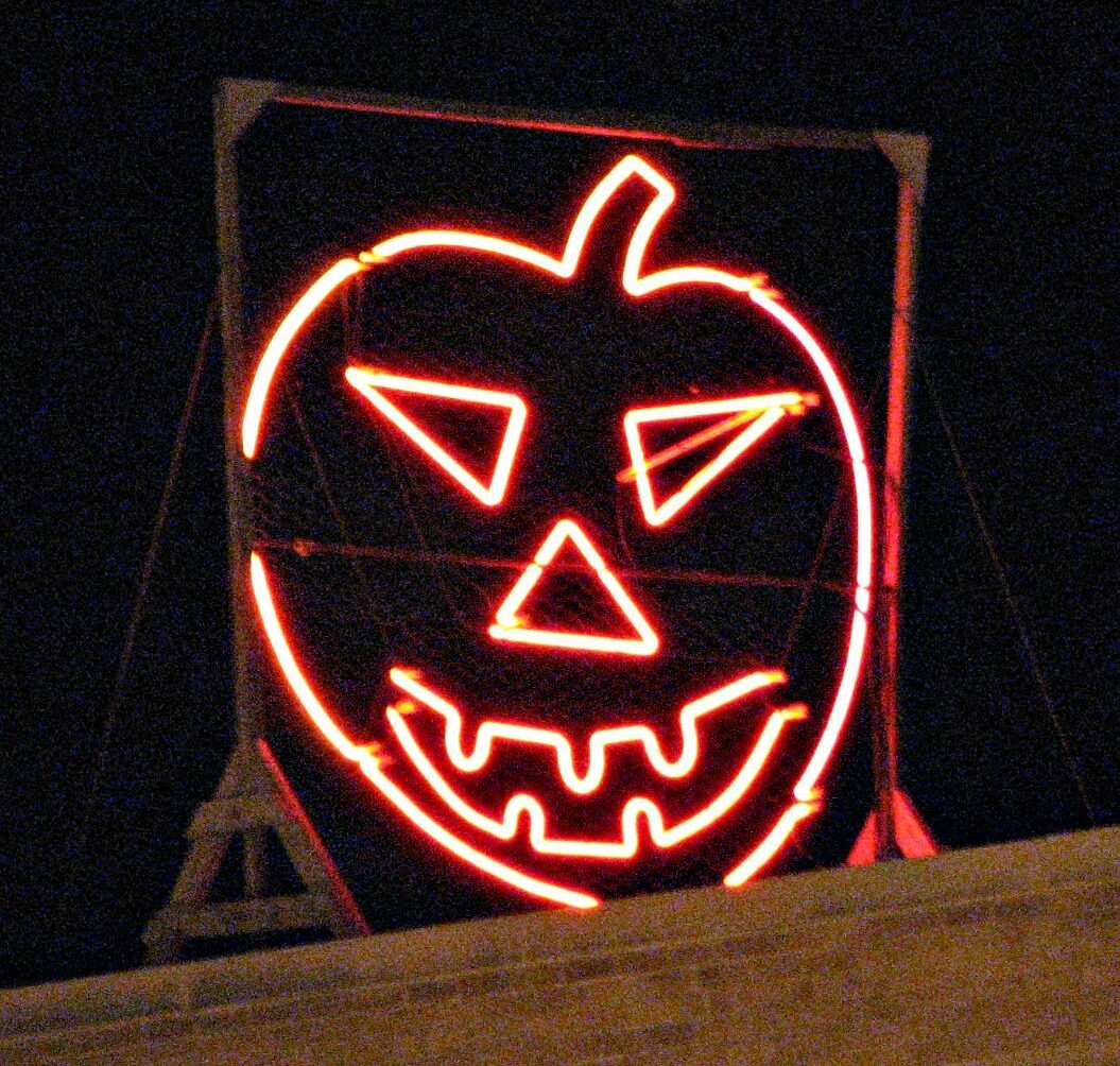 A glowing jack-o-lantern structure at nighttime.