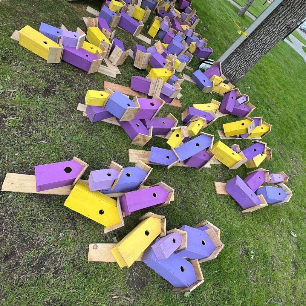 A mass of painted purple birdhouses