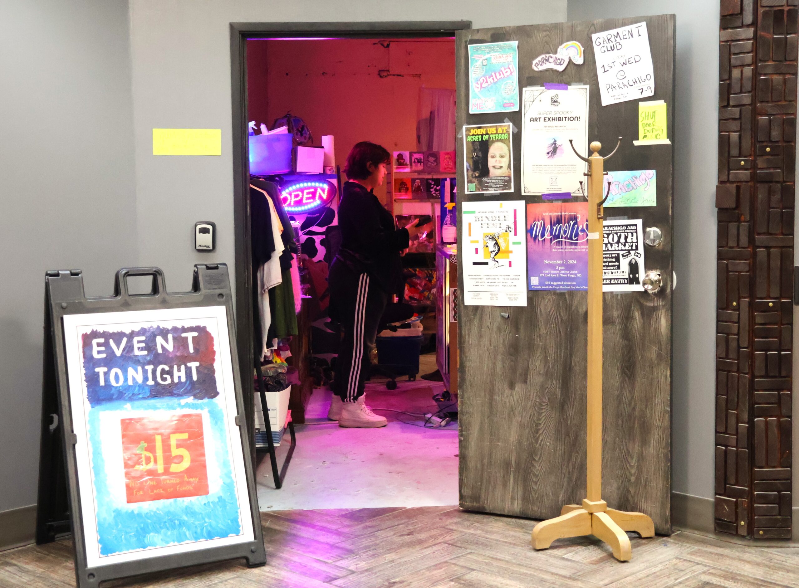 An open doorway looking into a room with colored lights. There are small posters stuck to the door.