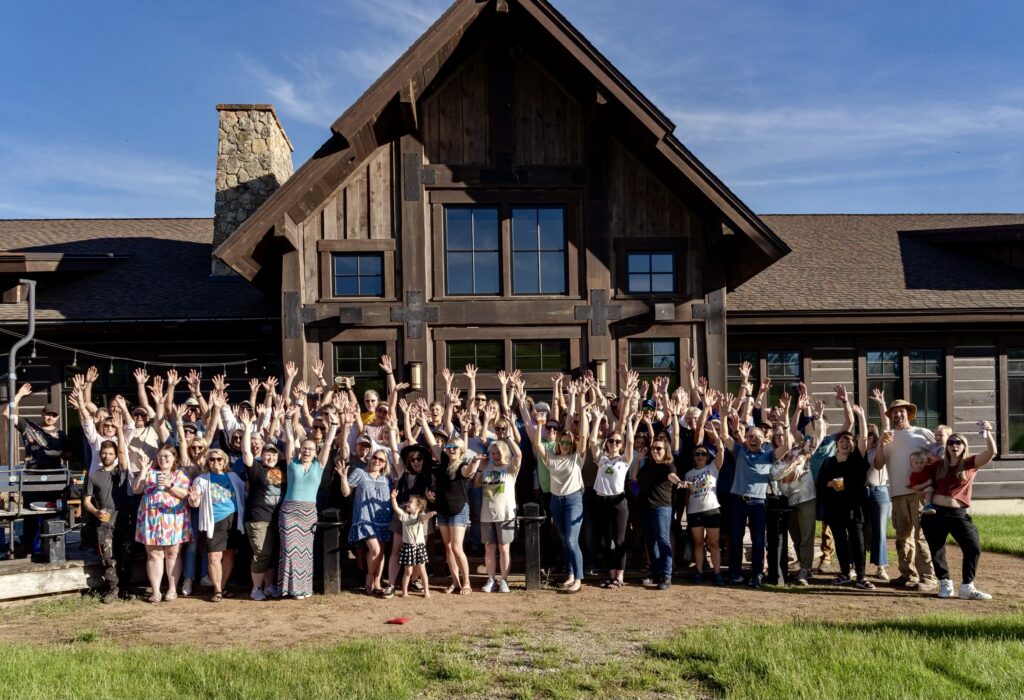 A large group of people celebrating with their hands up.