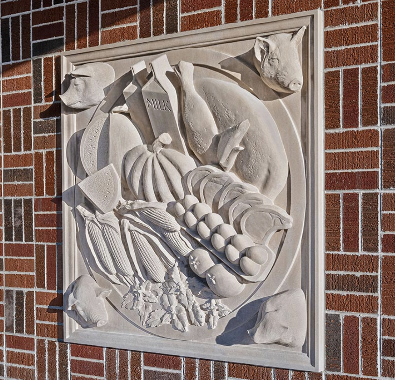 A stone carving depicting a collection of produce and other agricultural products.